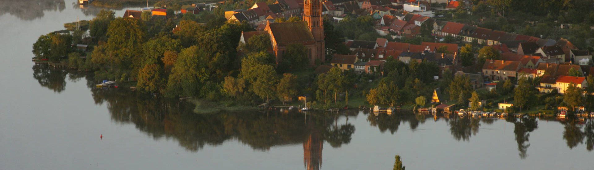 Luftbild von Röbel mit den beiden Kirchen St. Marien östlich und Kirche Röbel am Marktplatz Bootssteg Morgennebel