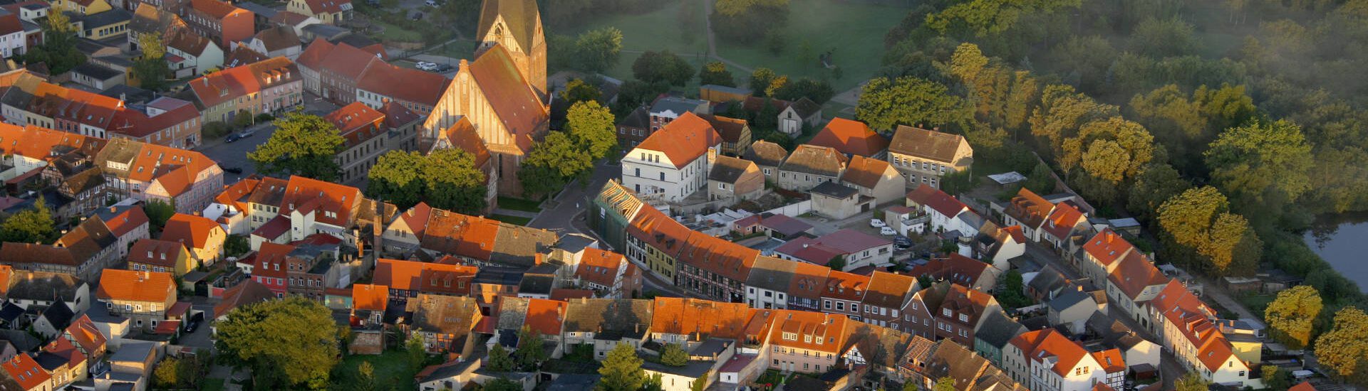 Luftbild auf Röbel mit den beiden Kirchen St. Marien östlich und Kirche Röbel am Marktplatz Bootssteg Morgennebel